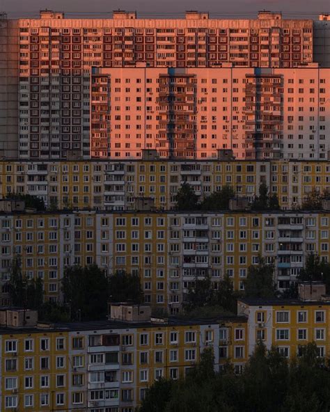 The Sun Is Setting Over Some Tall Buildings In This City With Trees