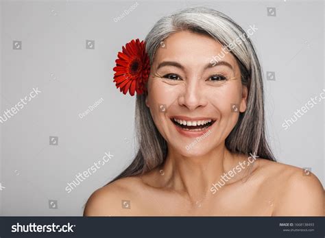 Beauty Portrait Of An Attractive Smiling Mature Topless Woman With Long Gray Hair Standing