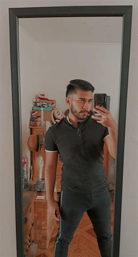 A Man Standing In Front Of A Mirror Taking A Selfie With His Cell Phone