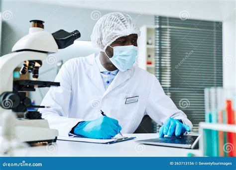 Adult Black Man As Scientist Using Laptop Doing Research In Laboratory