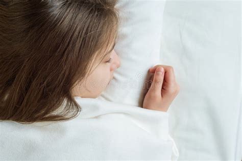 Bambino Della Ragazza Con Capelli Marroni Lunghi Che Dorme Su Un