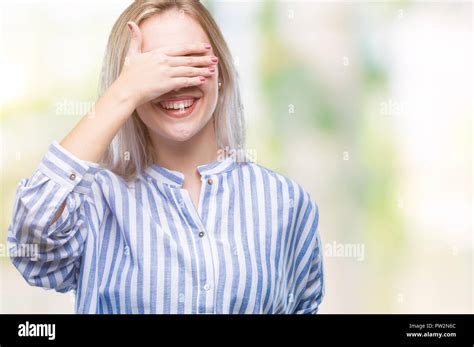 Junge blonde Frau über isolierte Hintergrund Lächeln und Lachen mit der Hand auf das Gesicht