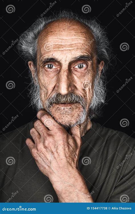 Old Man With A Plam On The Chin Loking At The Camera With Scared