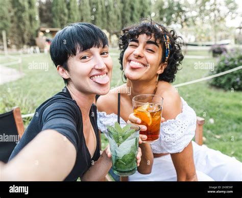 Delighted Multiracial Best Female Friends With Glasses Of Cocktails