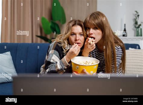 Two Women Of Different Ages Watch Horror Movie And Eat Popcorn While