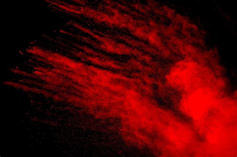 Nube de explosión de polvo rojo sobre fondo negro movimiento congelado