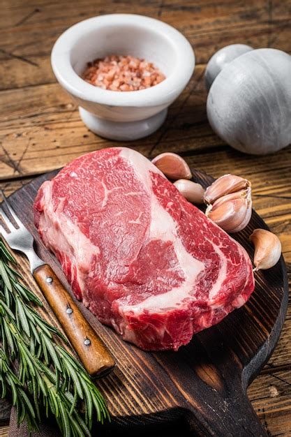 Premium Photo Raw Rib Eye Steak Ribeye Beef Meat On Wooden Board With