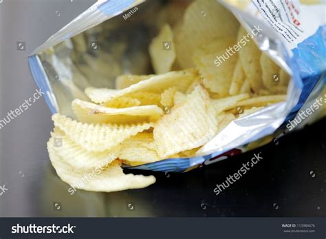 Opened Pack Of Delicious Spicy Potato Chips Over Black Table Open Bag