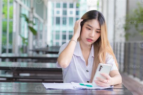 Portrait Of Cute Asian Thai Girl Student In Uniform Is Sitting Work