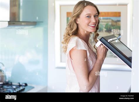 Pretty Blonde Opening The Oven Stock Photo Alamy