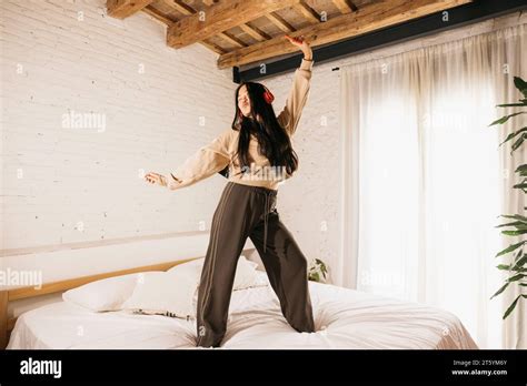 Young Chinese Woman Listening Music With Headphones And Dancing On A