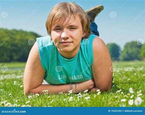 Menino Do Adolescente Que Encontra Se Na Grama Foto De Stock Imagem