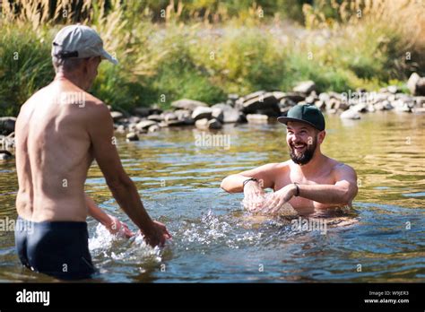 Father And Son Having Fun In The River Water On A Hot Summer Day Stock