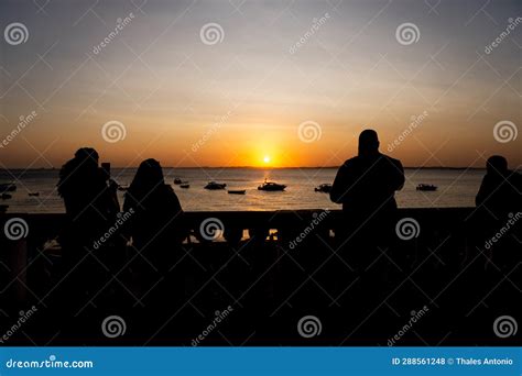 People Are Enjoying The Sunset At Porto Da Barra In The City Of