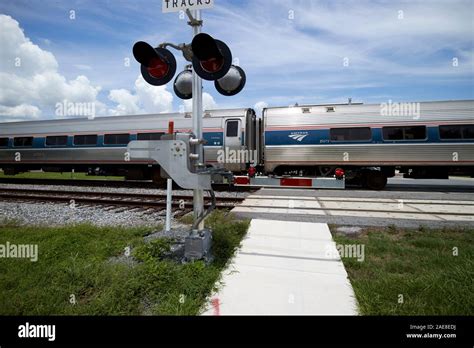 amtrack train crossing road behind barriers at train pedestrian railroad level crossing near ...