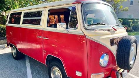 an old red and white van parked in a parking lot