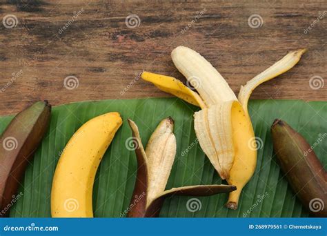 Different Types Of Bananas And Fresh Leaf On Wooden Table Flat Lay