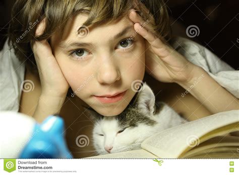 Livro De Leitura Do Menino Do Adolescente O Gato Na Cama Foto De