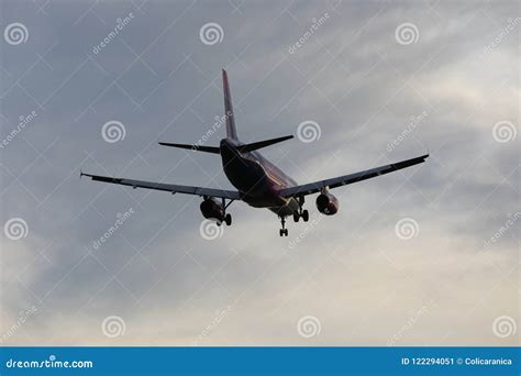 Silhouette Of Spotter Photographer Capturing Photos Of Landing Airliner