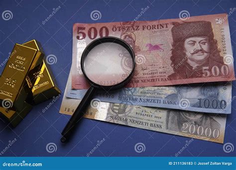 Several Hungarian Forint Paper Money Denominations And Gold Bars On A