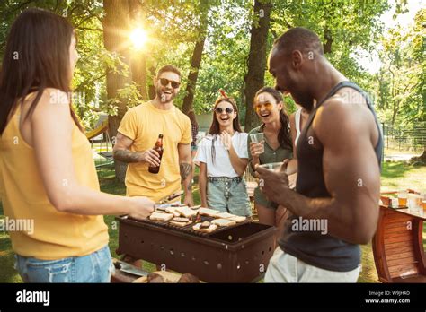 Group Of Happy Friends Having Beer And Barbecue Party At Sunny Day