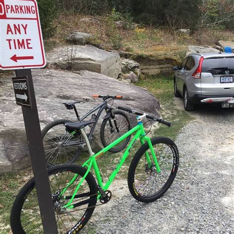 Two Bikes Parked Next To Each Other In Front Of A Parking Sign With An