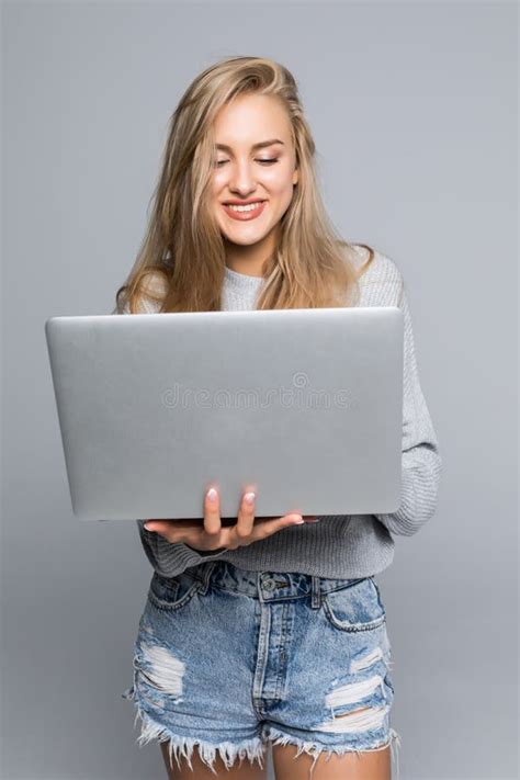 Portrait Of Happy Woman Standing With Laptop Isolated On Gray