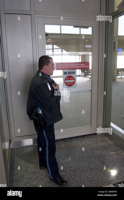 Police Officer Conducting Security Check In Airport Making Sure Doors