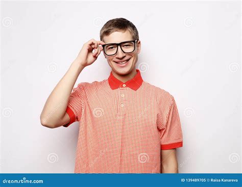 Portrait Of A Smart Young Man Wearing Eyeglasses Standing Against White