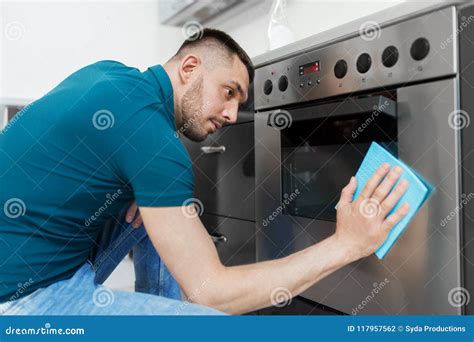 Homem A Cozinha Da Porta Do Forno Da Limpeza De Pano Em Casa Foto