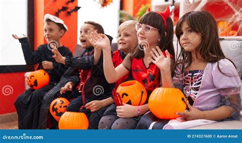 Group of Kids Wearing Halloween Costume Saying Hello with Hand at Home ...