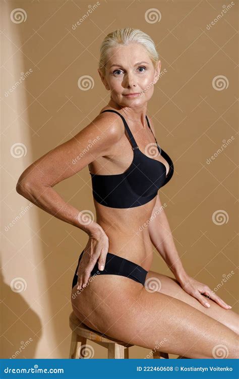 Studio Shot Of Beautiful Mature Woman In Black Underwear Looking At