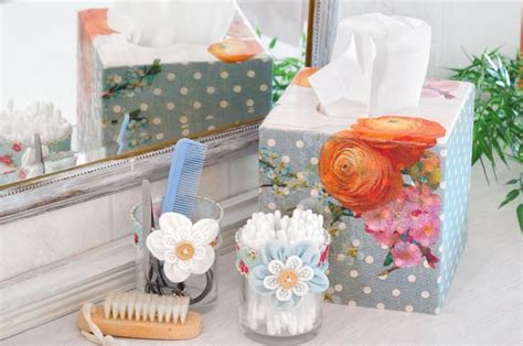 Two Boxes With Flowers On Them Are Sitting Next To A Brush And Soap