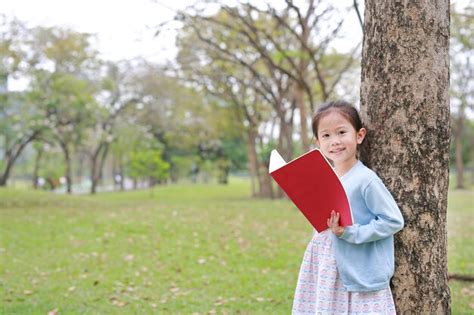 Premium Photo Portrait Little Asian Child Girl Reading Book In Park