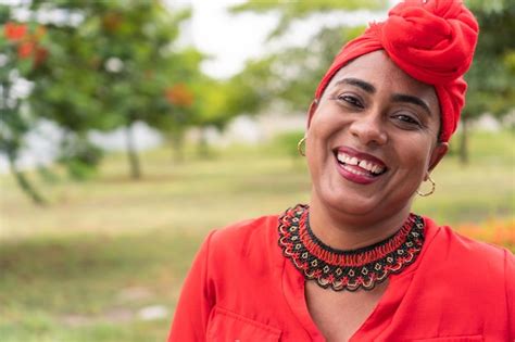 Retrato de un mujer latina sonriente mientras posición en un parque Foto Premium