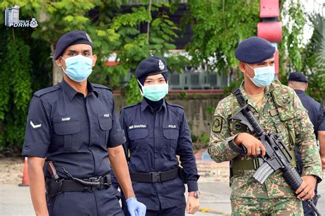 Royal Malaysian Police Officer Aided By Soldiers Manning The Roadblock