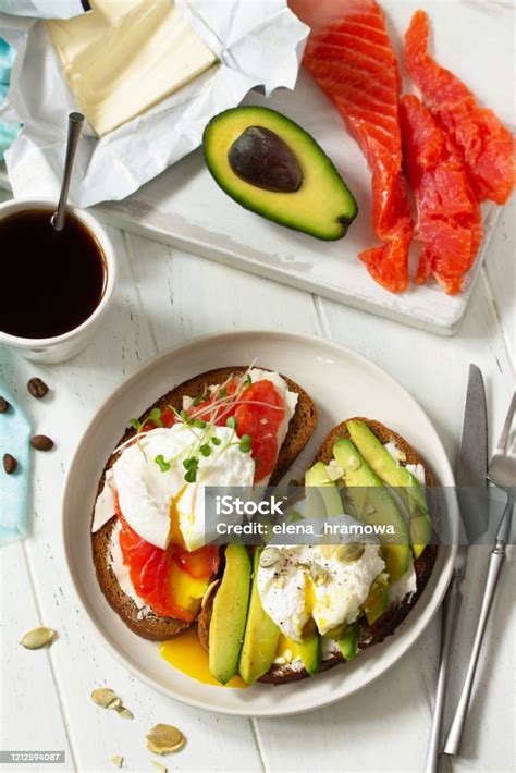 아침 식사 다진 달걀 삶은 샌드위치와 아보카도 연어 커피를 나무 테이블에 얹어 드세요 상단보기 평면 누워 배경입니다 아보카도에