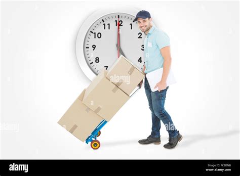 Composite Image Of Confident Delivery Man Pushing Trolley Of Boxes