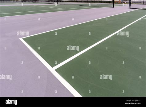 New Outdoor Green Tennis Courts With White Lines And Gray Out Of Bounds