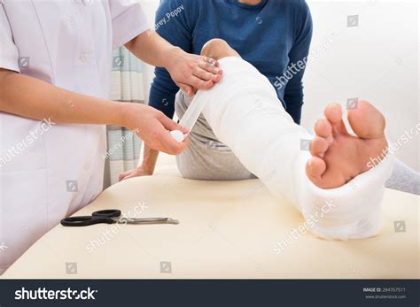 Closeup Female Doctor Bandaging Patients Leg Stock Photo Edit Now