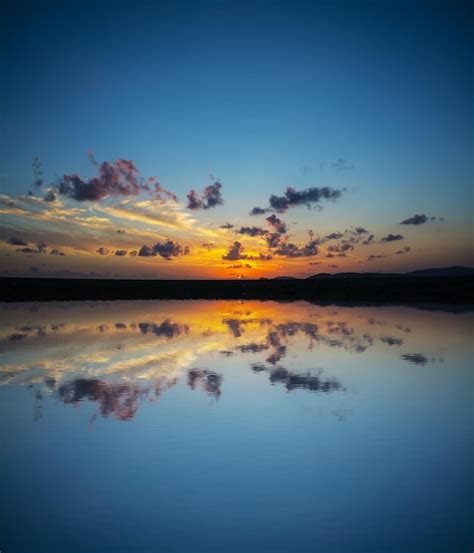 Premium Photo Dramatic Sky Reflected In The Water At Sunset