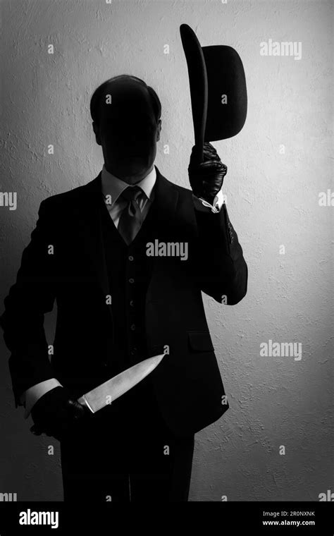 Portrait Of Shadow Man In Dark Suit Holding Bowler Hat And Sharp Knife