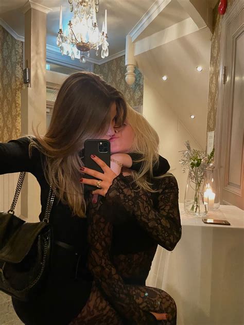 Two Women Taking A Selfie In Front Of A Mirror