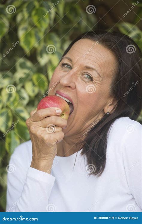 Happy Mature Woman Eating Apple Stock Image Image Of Confident Friendly