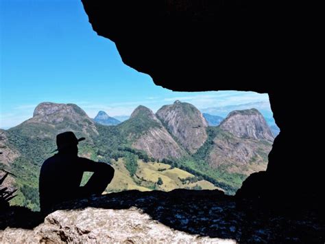 Vista Trasera De La Silueta De Un Hombre Sentado En Una Roca Contra El