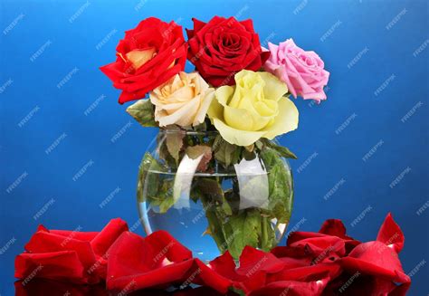 Premium Photo Beautiful Roses In Glass Vase On Blue Background