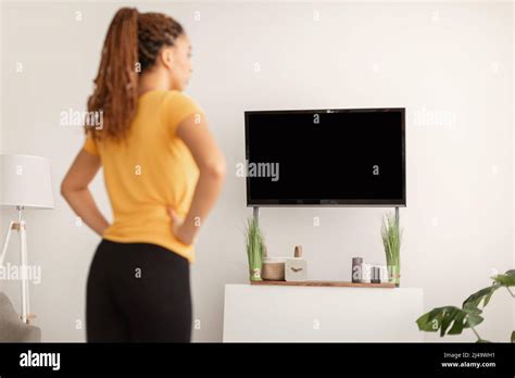 Fitness Female Exercising Watching Workout On Television Indoor Back