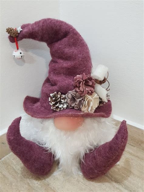 A Purple And White Gnome Hat On Top Of A Wooden Floor Next To A Wall