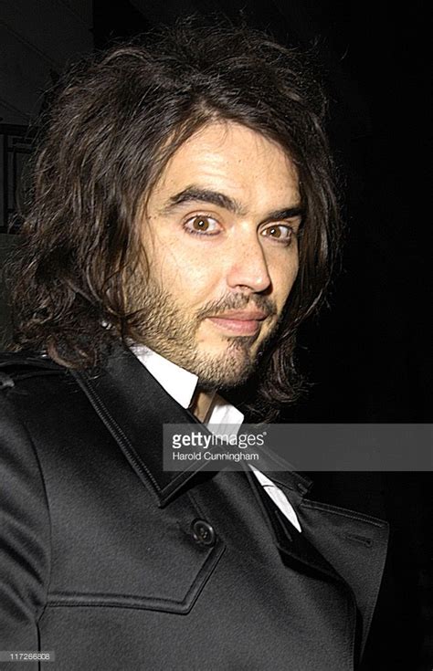 a man with long hair wearing a black suit and white shirt is looking at ...