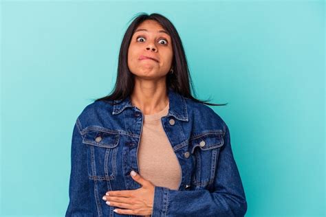 Jovem Mulher Latina Isolada Em Um Fundo Azul Toca A Barriga Sorri Suavemente Comendo E O